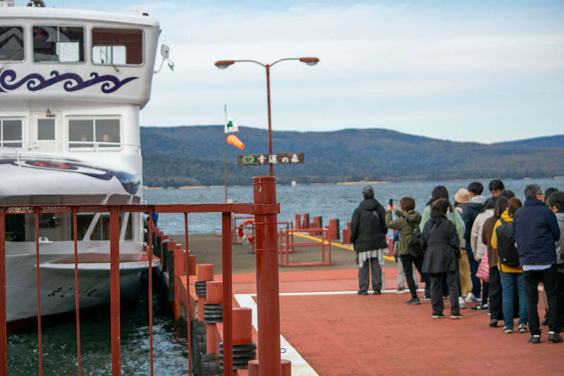 Passengers boarding the sightseeing ferry to Churui Island at Lake Akan, Japan — gateway to the Marimo Exhibition Center.