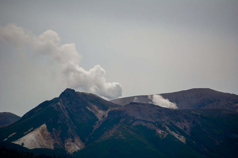 Steam billows from Mount Meakan’s sulfur-stained slopes, viewed from a ferry near Kushiro, Japan.