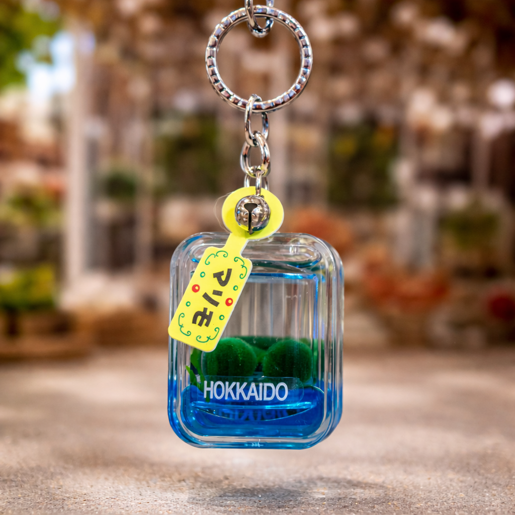 Blue marimo moss ball keychain with Hokkaido label hanging display style Lake Akan Japan souvenir