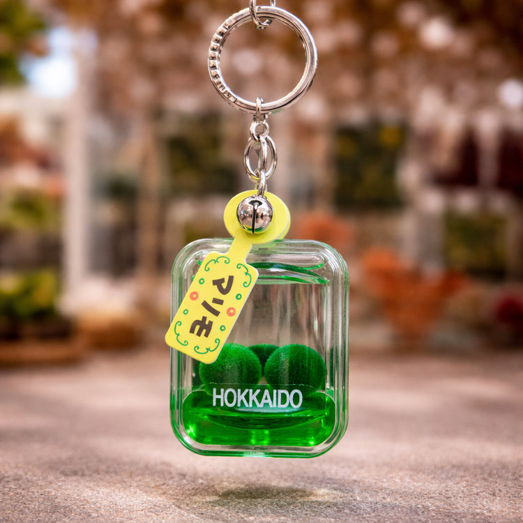 Green marimo moss ball keychain with Hokkaido label inspired by authentic Lake Akan Japan souvenir