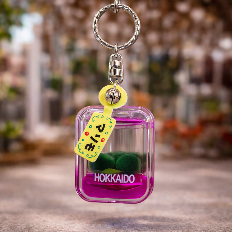Pink marimo moss ball keychain with Hokkaido label souvenir inspired by Lake Akan Japan