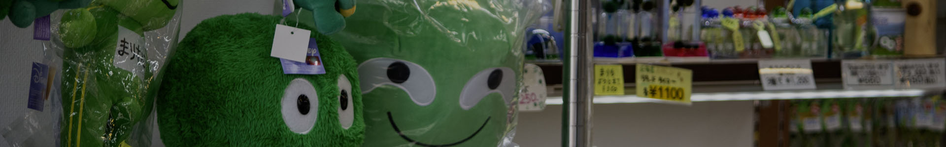 Marimo moss ball souvenirs on display at Akanko Onsen Village, including plush toys, glass terrariums, pens, keychains, and other collectibles.